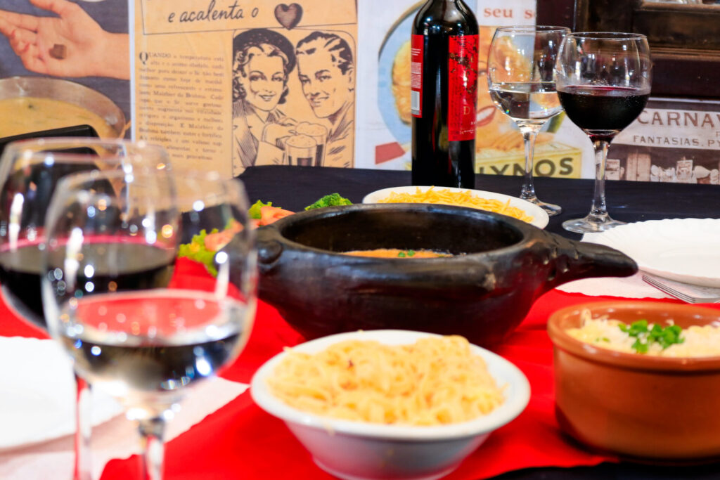 Imagem de uma mesa com alimentos e vinho
