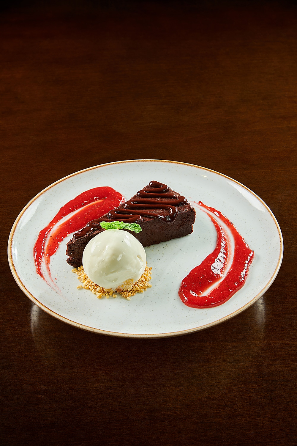 Torta de Chocolate servida com sorvete de baunilha e calda de berries